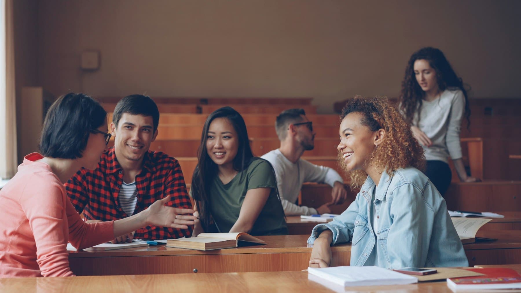 Students talking and laughing together in a lecture hall